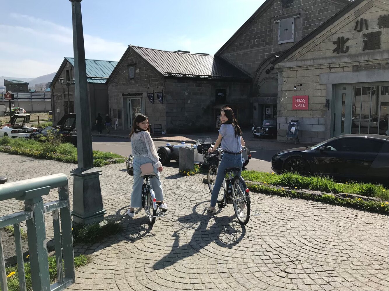 小樽運河の石造倉庫前を電動アシスト自転車で走る利用者